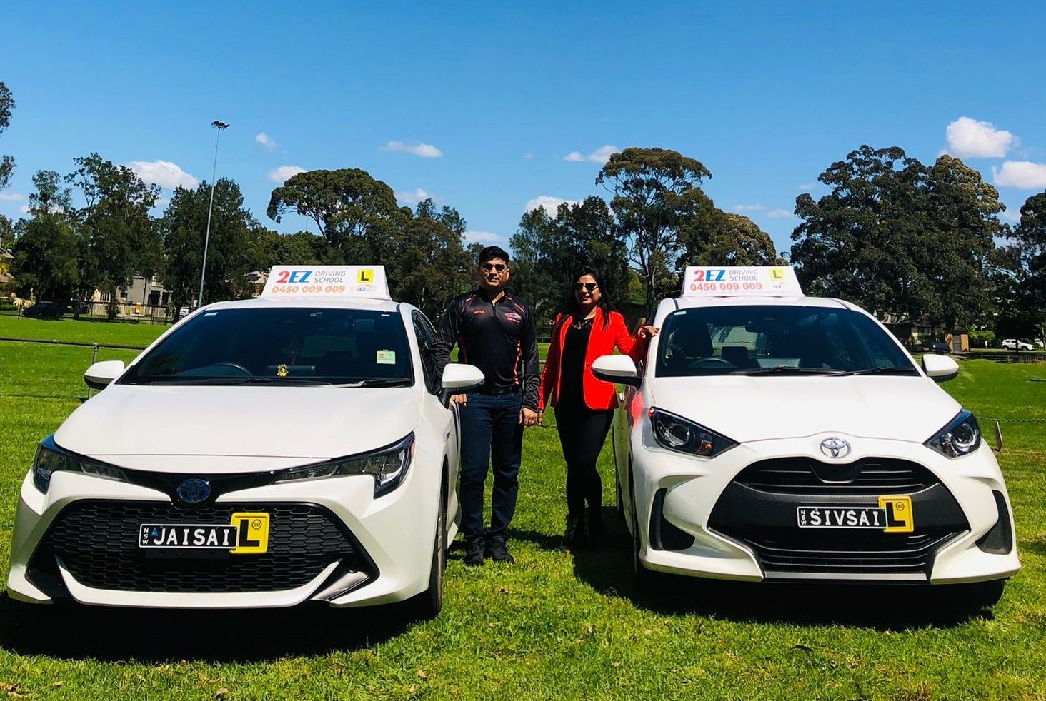 The 2EZ instructors standing between the two 2EZ Toyota cars